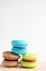 Stack of Vibrant colorfull macarons on white wooden table.