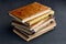 Stack of vintage dilapidated books on a dark concrete table