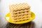 Stack of wafers in saucer on wooden table