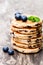 Stack of welsh cakes with blueberry and mint leaves on wooden b