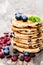 Stack of welsh cakes with blueberry and mint leaves on wooden b