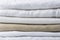Stack of white and beige pure organic cotton and linen folded fabric. Clothing laundry home textile sewing concept