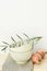 Stack of White Empty Bowl Olive Oil Tree Branch Linen Napkin Yellow Onions on Wood Kitchen Table. Provence Mediterranean Style