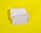 A stack of white rectangular business cards on a yellow background, company branding, address