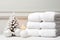 A stack of white towels sitting next to a christmas tree.