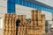 A stack of wooden pallets in an internal warehouse. An outdoor pallet storage area under the roof next to the store. Piles of Euro