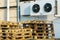 A stack of wooden pallets in an internal warehouse. An outdoor pallet storage area under the roof next to the store. Piles of Euro