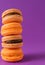 Stack of yellow and beige macaroons on a purple