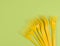 stack of yellow plastic forks on a green background, top view