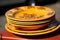 Stack of Yellow Porcelain Plates with Beautiful Flower Ornament on Elegant Dining Table