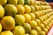 A stack of yellow ripe and sweet lines on the whole screen on the market. Lime and lemons background. Fresh organic lemons and