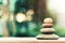 Stack of zen stones on ground with blurred nature background.