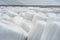 Stacked bales of harvested hay wrapped with plastic film at the