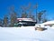 Stacked canoes and a sail boat covered in snow in Minnesota winter scene