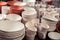Stacked ceramic bowls, dishes and mugs, clay handmade products pots are waiting for baking in kilns in the potter`s studio