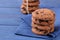 Stacked chocolate cookies in stack on beautiful napkin on blue wooden table. bake. yummy