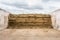 Stacked and compressed hay bales with concrete walls on the side.