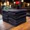 Stacked dark-colored blankets and towels on a table