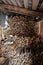 Stacked firewood in an old barn, partially covered with snow through the plank walls. Heating season in the village