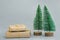 Stacked gift boxes wrapped in craft paper tied with twine Christmas trees on grey background. New Year corporate presents shopping