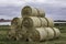 Stacked like a pyramid, round yellow bales of straw in the cloudy weather.