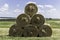 Stacked like a pyramid, round yellow bales of straw in sunny weather.