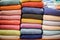 Stacked multicolored clothing fabric in the closet bed linen banner.