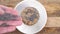 Stacked oatmeal cookies in a white plate on a rustic wooden background.