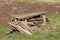 Stacked old broken heavily used homemade wooden garden stakes mixed with wooden boards next to makeshift wooden bench