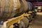 Stacked pile of old wooden barrels and casks in aging cellar at