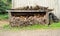 Stacked pile of seasoned cut logs under a rickety lean to