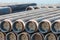 Stacked pipeline tubes lay in outdoor storage