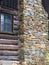 Stacked rock chimney on wood log cabin