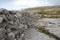 Stacked rock wall cuts through The Burren limestone karst