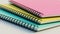 Stacked spiral binder notebooks. Blank colourful notebooks. Closeup side view.