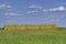 Stacked square bales of hay in a farm field