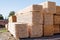 Stacked stacks of wooden planks against the sky. Lumber warehouse, wood drying.