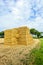 Stacked straw bales in front of a large stubble field