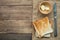 Stacked toasted slice sandwich bread with butter in wooden bowl and stainless knife on gunny sack cloth on wood table