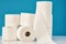 Stacked toilet paper rolls on a blue background. Hygiene concept