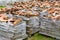 Stacked weathered red roof tiles on ground