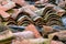 Stacked weathered red roof tiles on ground