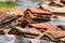 Stacked weathered red roof tiles on ground