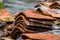 Stacked weathered red roof tiles on ground