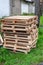 Stacked wooden pallets are stacked on the streets outside the premises. Old pallets at the building on the road