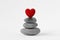 Stacked Zen stones with heart on white background - Concept of love and balance