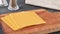Stacking sides of cheddar cheese on a cutting board