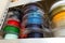 Stacks of 3d printing filament in different colors lying on shelf