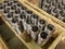 stacks of batch production round parts in a wooden boxes on factory floor