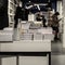 Stacks of books on table, modern urban bookshop, library. Unrecognizable silhouettes of people. Education concept